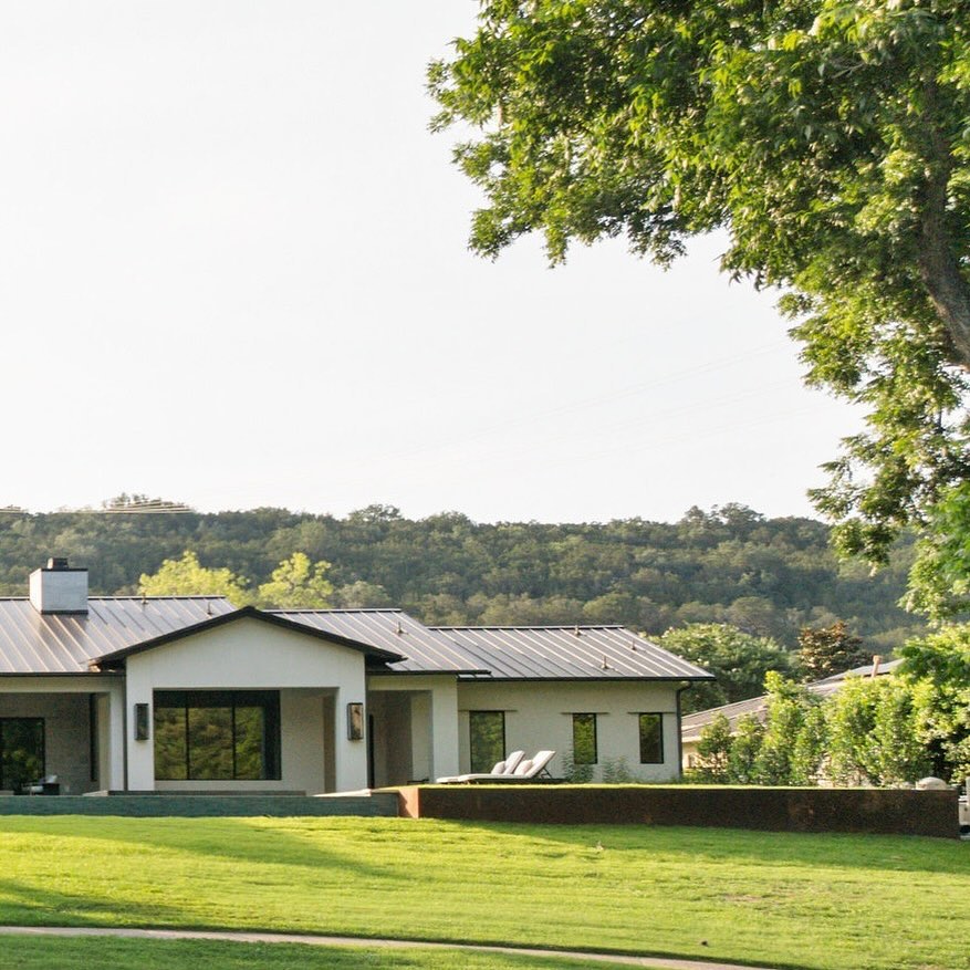 Rear elevation with a limestone terrace and weathered corten steel wall opening to the landscape