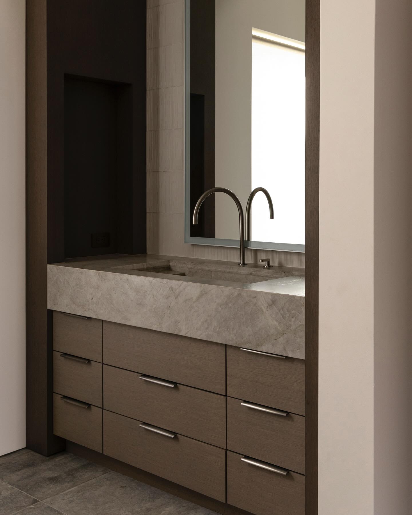 Trough sink carved from quartzite set into a rift-sawn oak vanity